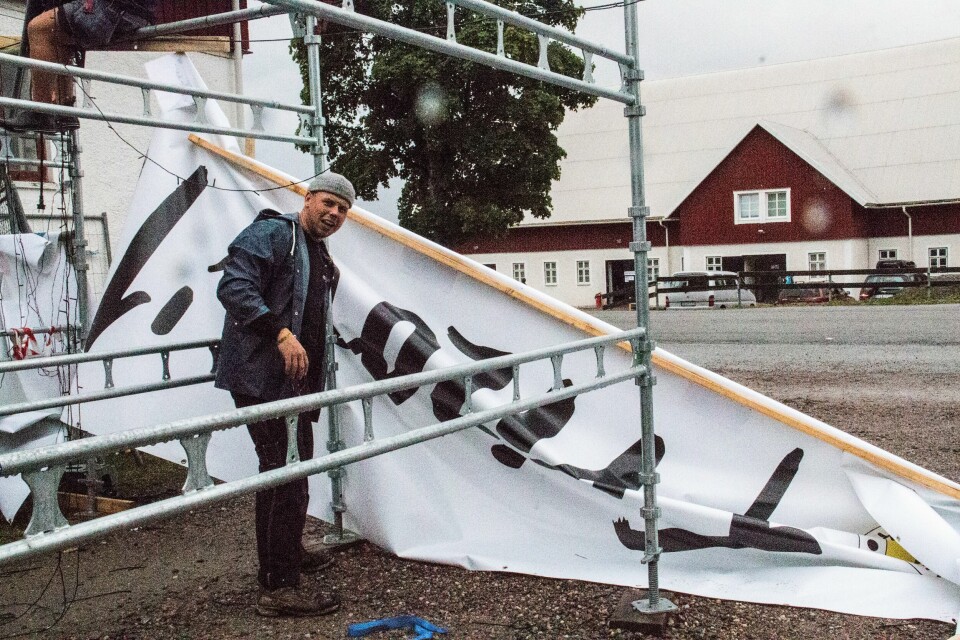 Josef Maxson, projektledare för Frizonfestivalen 2018, tar ner skylten för sista gången. Josef Maxson, projektledare för sista Frizonfestivalen, plockar ner entréskylten.