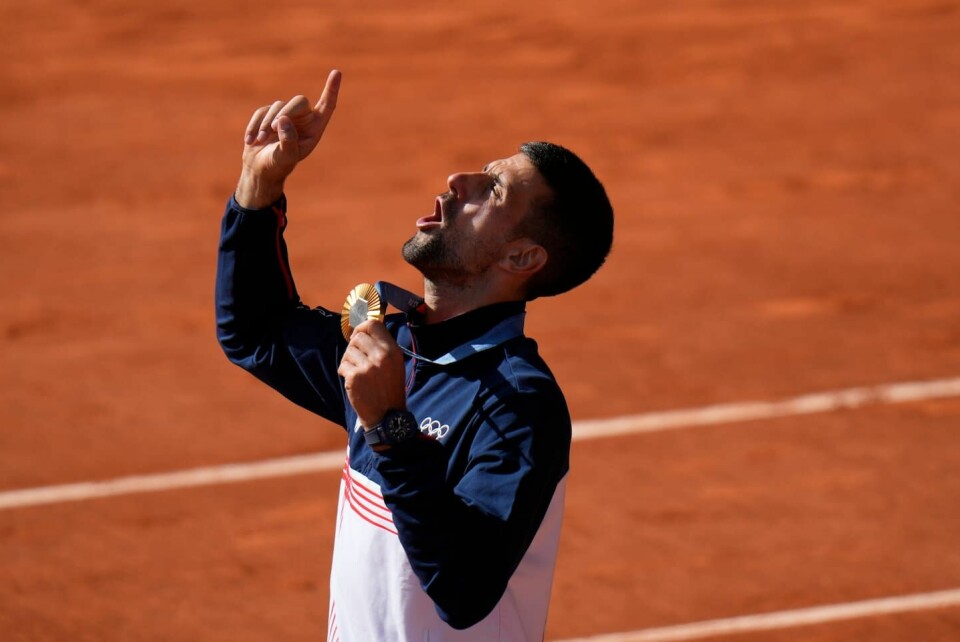 Serben Novak Djokovic håller i sin guldmedalj och riktar tacksamheten uppåt.