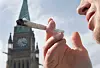 A demonstrator smokes a marijuana joint on Parliament Hill in Ottawa on Tuesday, April 20, 2010. (AP Photo/The Canadian Press, Pawel Dwulit)