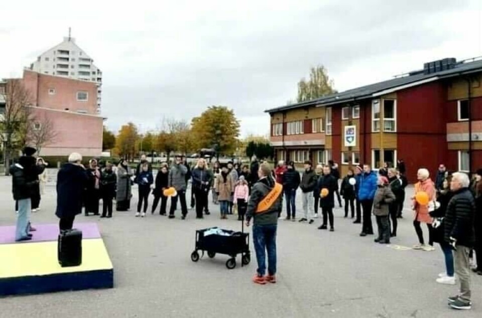 Under fredsvandringen genom Vivalla i Örebro stannade deltagarna till vid några stationer där talare gav inspiration till att stå upp för människovärdet. En grupp människor står utomhus framför en scen och lyssnar på en person som talar.