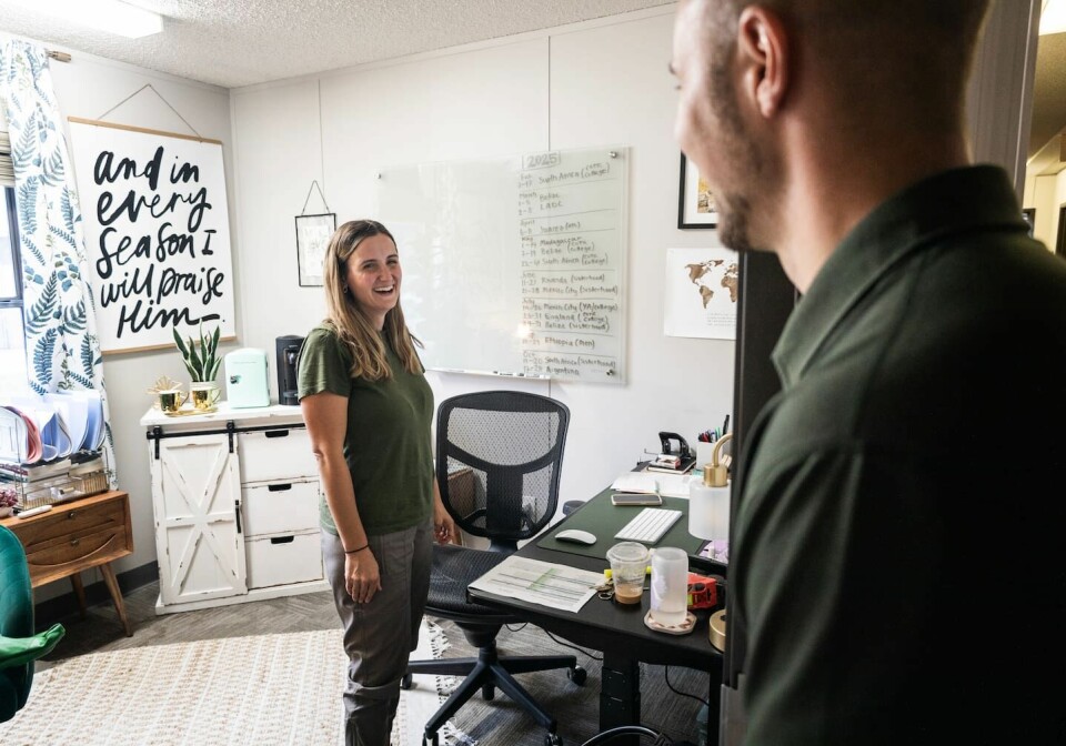 Rebecca och Simon Andersson träffades i Sverige första gången 2015. Numera är de gifta och dessutom kollegor. På tavlan i bakgrunden är missionsresorna som Rebecca ansvarar för nästa år uppskrivna. Simon Andersson växte upp i Norrbotten, men flyttade som tioåring till USA, i dag arbetar han som online pastor i Church of the King i Louisiana