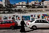 Omtvistat område. En palestinsk kvinna går längs en mur vid en skola i statsdelen Silwan strax utanför Gamla muren i östra Jerusalem. Ir David (Davids stad) ligger delvis i Silwan där en majoritet av invånarna är palestinier.