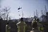 Israeliska brandmän ser på när en helikopter släpper vatten över bränderna.