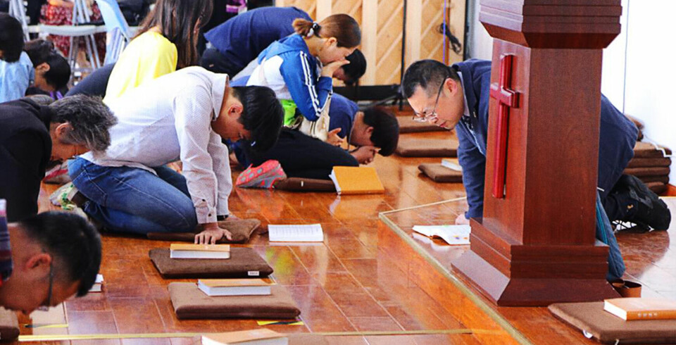 Pastor Wang Yi and the congregation members in morning prayer before a Sunday service.